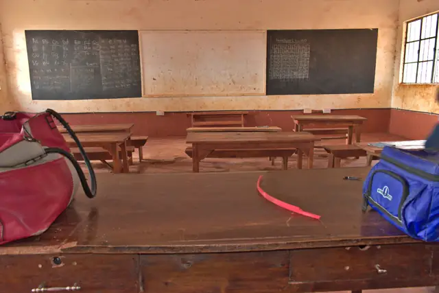 Wooden desks and a chalkboard in a rural classroom